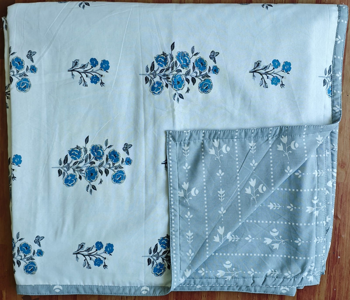 White and grey combination reversible double bed dohar on a bed